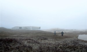 People walk toward a building in a fog bank