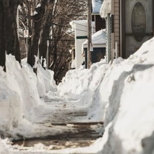 人行道已被清理干净，但仍有一小块一小块的积雪，积雪有一到几英寸深。