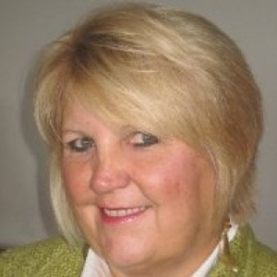 一个白色背景下身穿绿色毛衣的中年金发白女人的特写