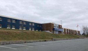 在一个阴天，你可以从灰色的停车场看到安德鲁王子高中。外面没有人。