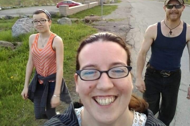 一张年轻女子和她的父母走在路上的照片