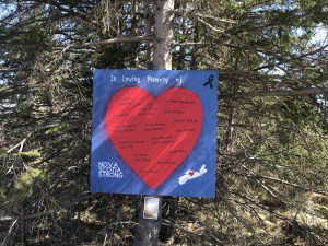 一张海报，蓝底红心，上面手写着名字