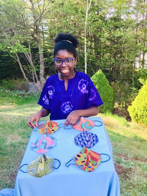 一个女孩在桌子上盖着她缝制的面具