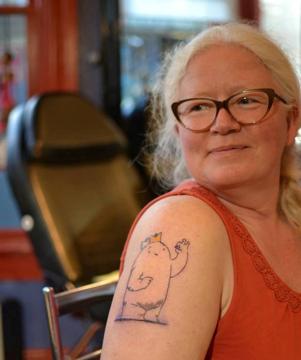 穿着背心的女人，二头肌上有纹身。