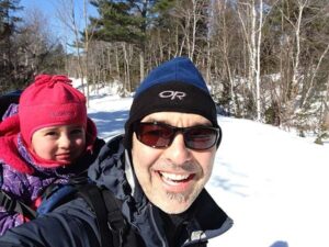 穿着冬衣，背着孩子的微笑男人