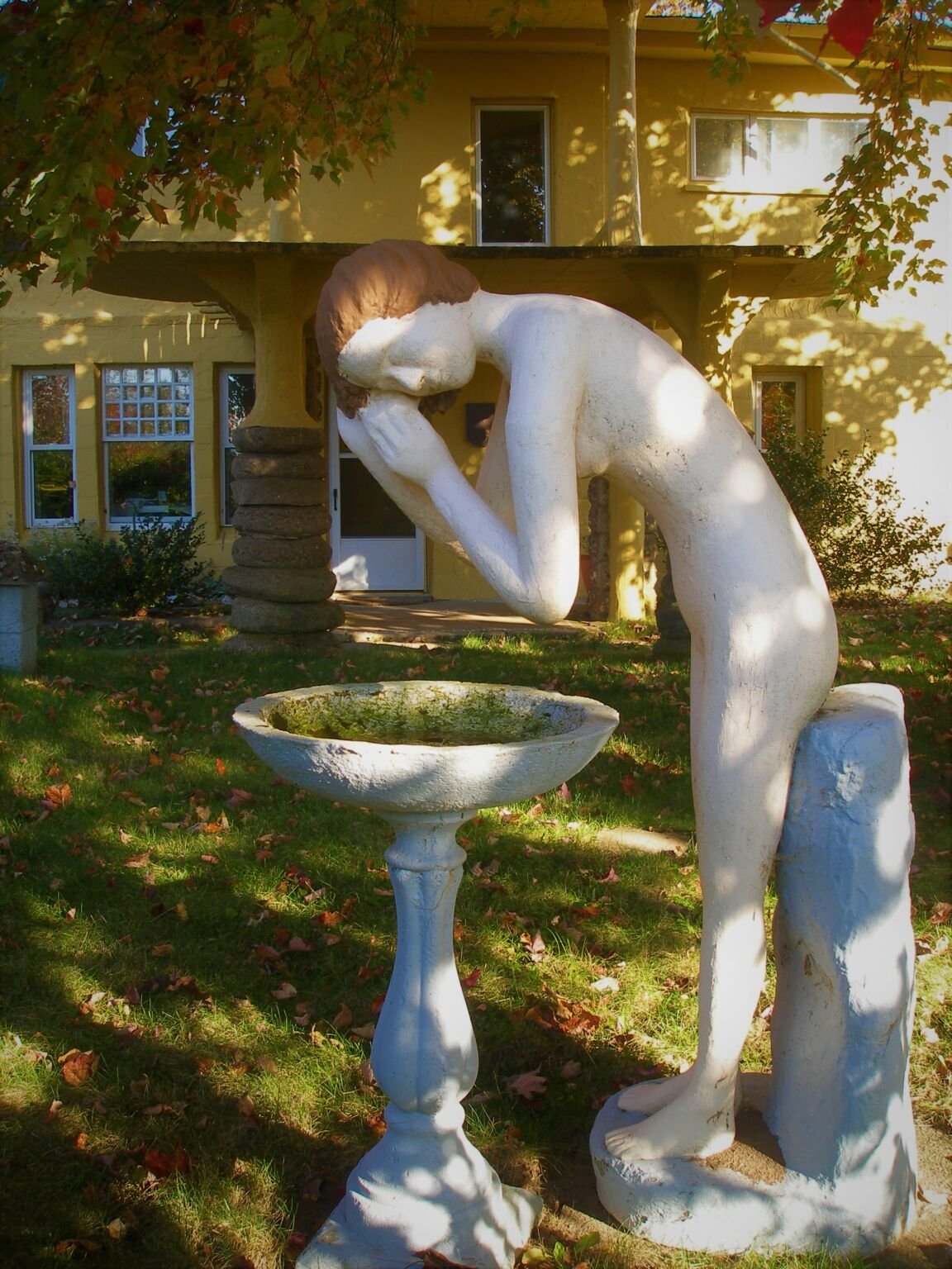 一个女人在水盆上洗头发的具体形象。