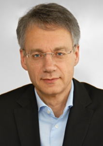 一个穿西装戴眼镜的男人的大头照