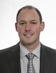 一个穿夹克打领带的略秃男人的大头照。