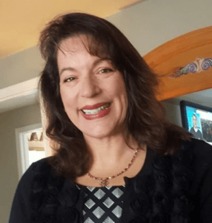 有肩长棕色头发的一名微笑的中年白人妇女的爆头。