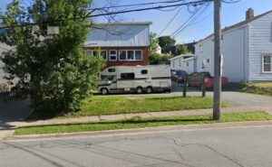 一栋两层建筑的街道图象与露营车的露营车停在它前面。