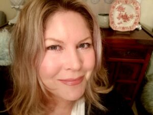 一张照片，也许是selie golding的自拍照。她有肩长的金发，并在镜头上微笑。