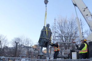 康沃利斯的雕像悬挂在半空中，正在从底座上移走