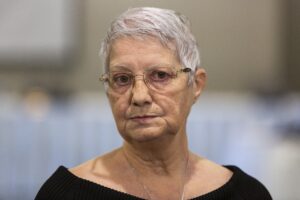 一个白发短发，戴着眼镜，身穿黑色上衣的女人的大头照。