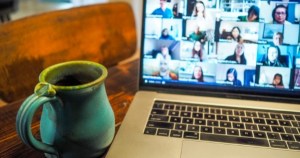 在笔记本电脑上参加Zoom会议，还有一杯热饮