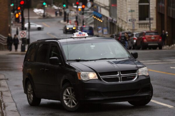 一辆可通行的黑色赌场出租车开上了一条崎岖的街道。