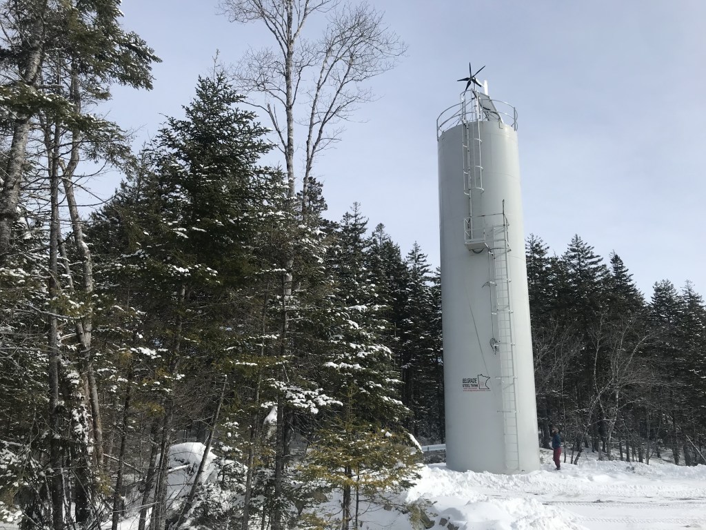 照片显示的是一个高大的锥形结构，这是一个石灰加药器，位于拟议中的比弗坝金矿下游的基拉格河边缘。图片:Joan Baxter