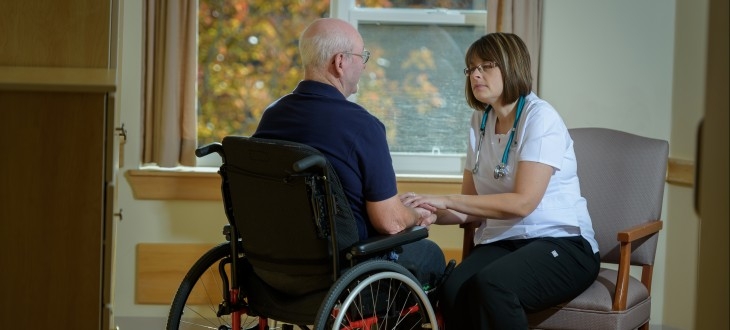 一个女人和一个坐轮椅的男人说话