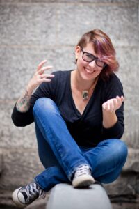 穿着牛仔裤和黑衬衫的微笑女人盘腿而坐