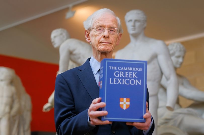 有白色头发的人在拿着书的雕象前面的雕象。