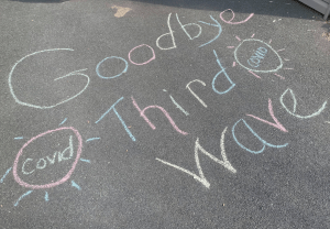 在一个阳光明媚的早晨，苏珊娜·伦特在自家车道上用彩色粉笔写下了“再见，第三波”，并附上了新冠病毒的图片。