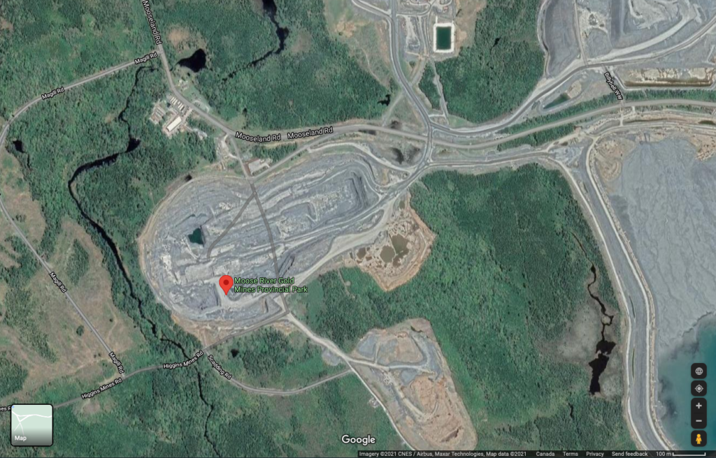 谷歌地图显示前驼鹿河金矿省公园在Touquoy露天矿坑内的位置。周围是大片灰色和米黄色的尘埃，还有原始森林的一些遗迹。