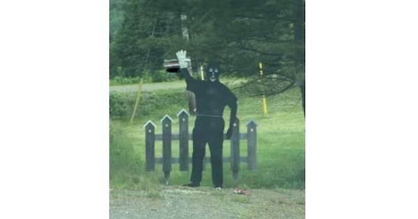 在Parrsborough竖立的黑面肖像的照片。除了卡通白色特征和右手上的一个白色手套之外，它是完全黑色的。在它背后是一个卡通黑色纠察围栏和绿色草坪。