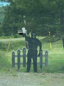 在Parrsborough竖立的黑面肖像的照片。除了卡通的白色特征和一款白色手套上，它是完全黑色的。在它背后是一个卡通黑色纠察围栏和绿色草坪。