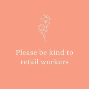 珊瑚色的正方形标志，奶油插图的两个玫瑰和奶油文本阅读“请善待零售工人”。