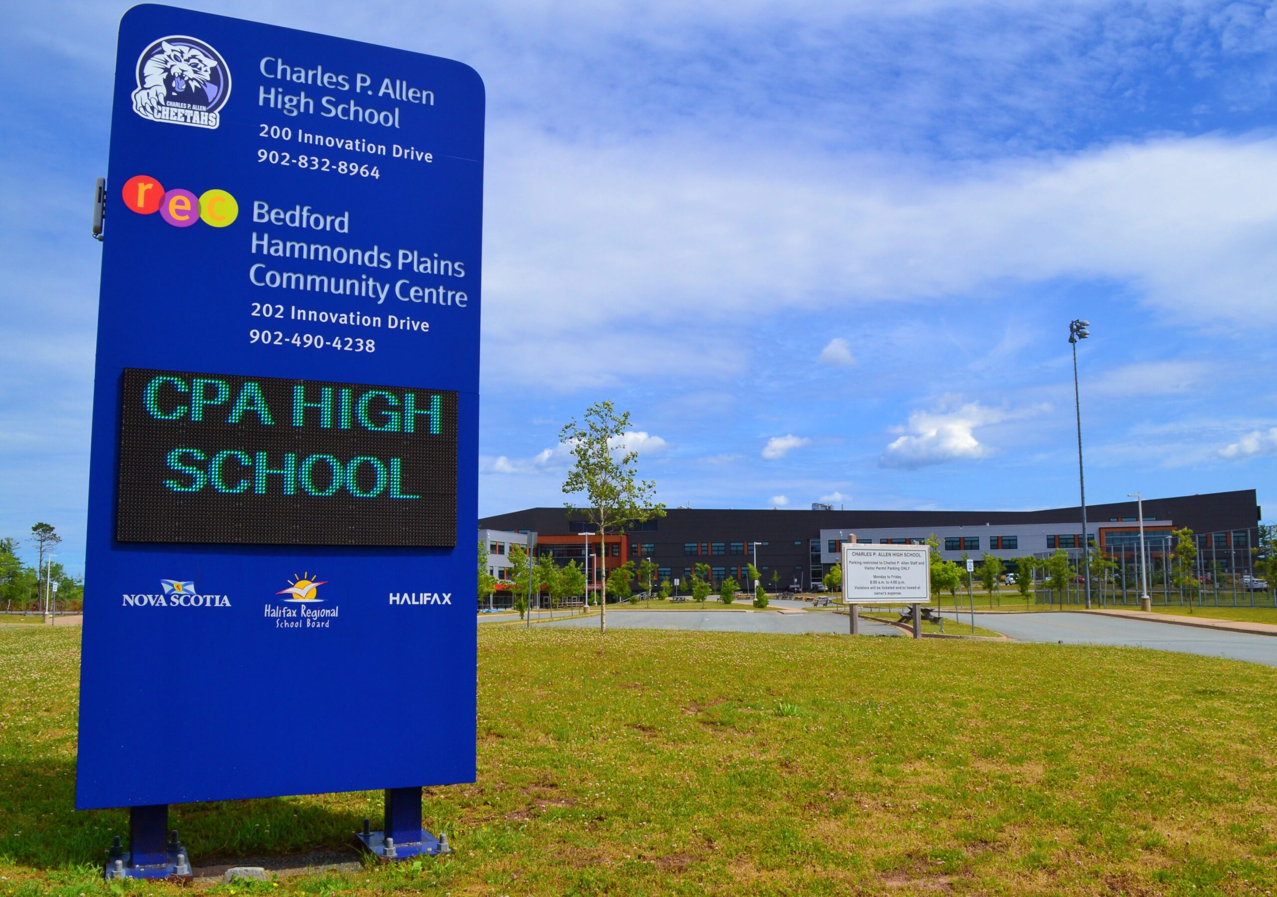 在查尔斯·艾伦体育高中和毗邻贝德福德哈蒙兹平原社区中心门前明亮的蓝色标志欢迎游客。