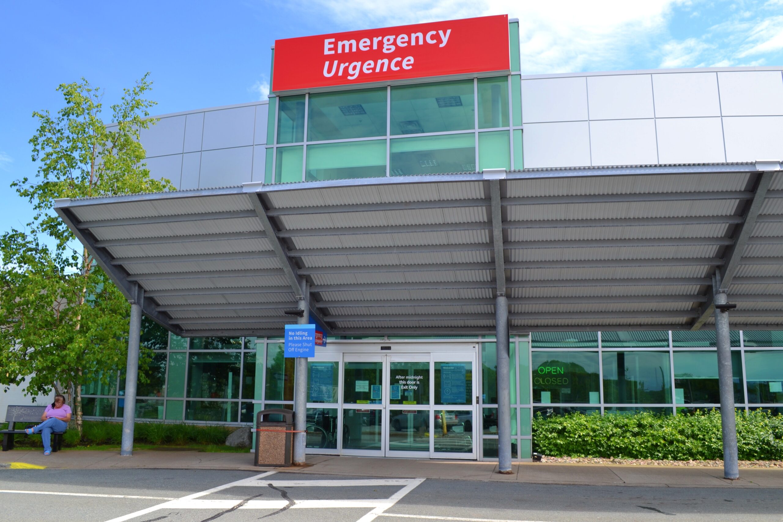 一名妇女在Cobequid社区卫生中心的紧急入口外看书。