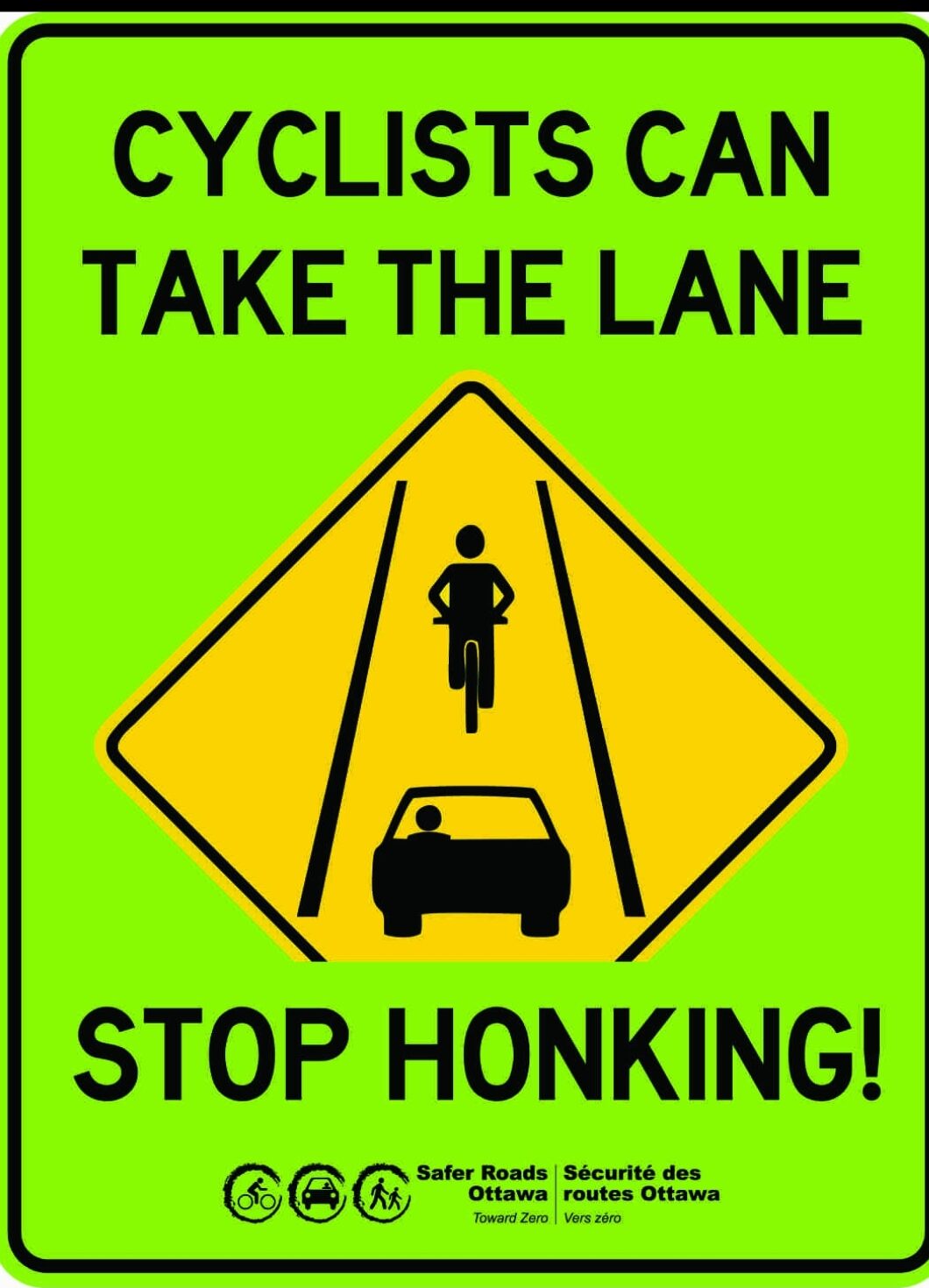 显示一件黄色金刚石的路标与自行车和汽车。文字说：骑自行车的人可以带走车道。停止鸣叫！“