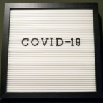 一个白色的标志与可移动的字母拼出covid 19