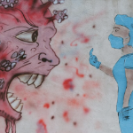 A mural with a large coronavirus with teeth, and a nurse in full PPE giving it a 