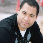 雅各布Samson，严肃地看着在户外拍的照片的照相机在阴暗的天。