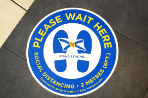 亮蓝色、白色和黄色的大流行社交距离地板标识。