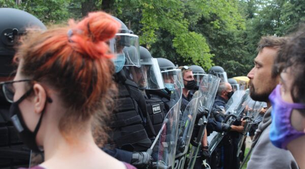 2021年8月18日，在驱逐无家可归者营地期间，手持盾牌和警棍的哈利法克斯警察在前纪念图书馆外与抗议者对峙。