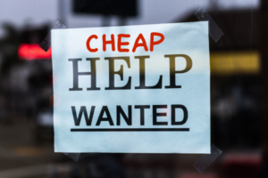 “便宜”这个词被加在贴在窗户内侧的一张招聘告示的顶部。