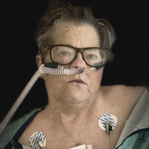 简·堪萨斯，她的鼻子里插着一根呼吸管，胸部上方绑着两根心电图线。