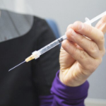 护士手拿着疫苗注射器的特写镜头。