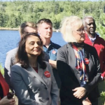 A handful of the Liberal candidates standing in front of a lake.