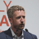 Iain Rankin speaking into two microphones