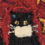One of the black kitties wearing a white mask in Laura Kenney's hooked rug