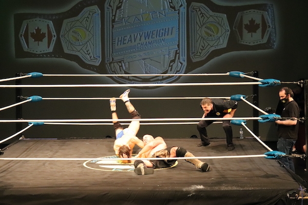 柯维·克里斯特在地板上做一个头球，他的脚在半空中。裁判蹲着看得更清楚。