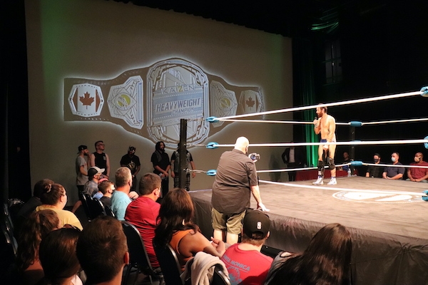 柯维·克里斯特站在拳台上拿着麦克风，看起来疲惫不堪