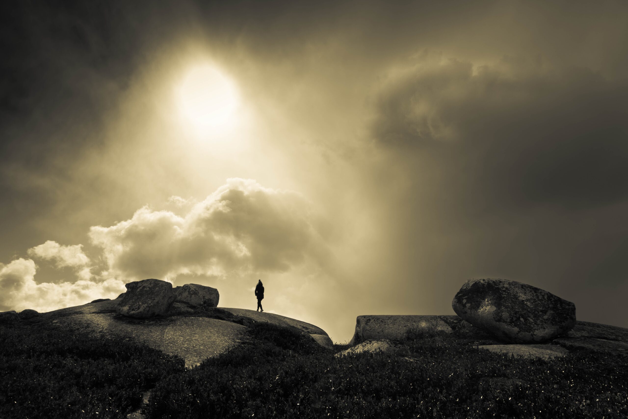一个女人站在引人注目的多云天空的衬托下。