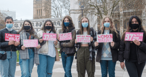 在伦敦，7名年轻女子举着标语抗议性骚扰和街头骚扰。