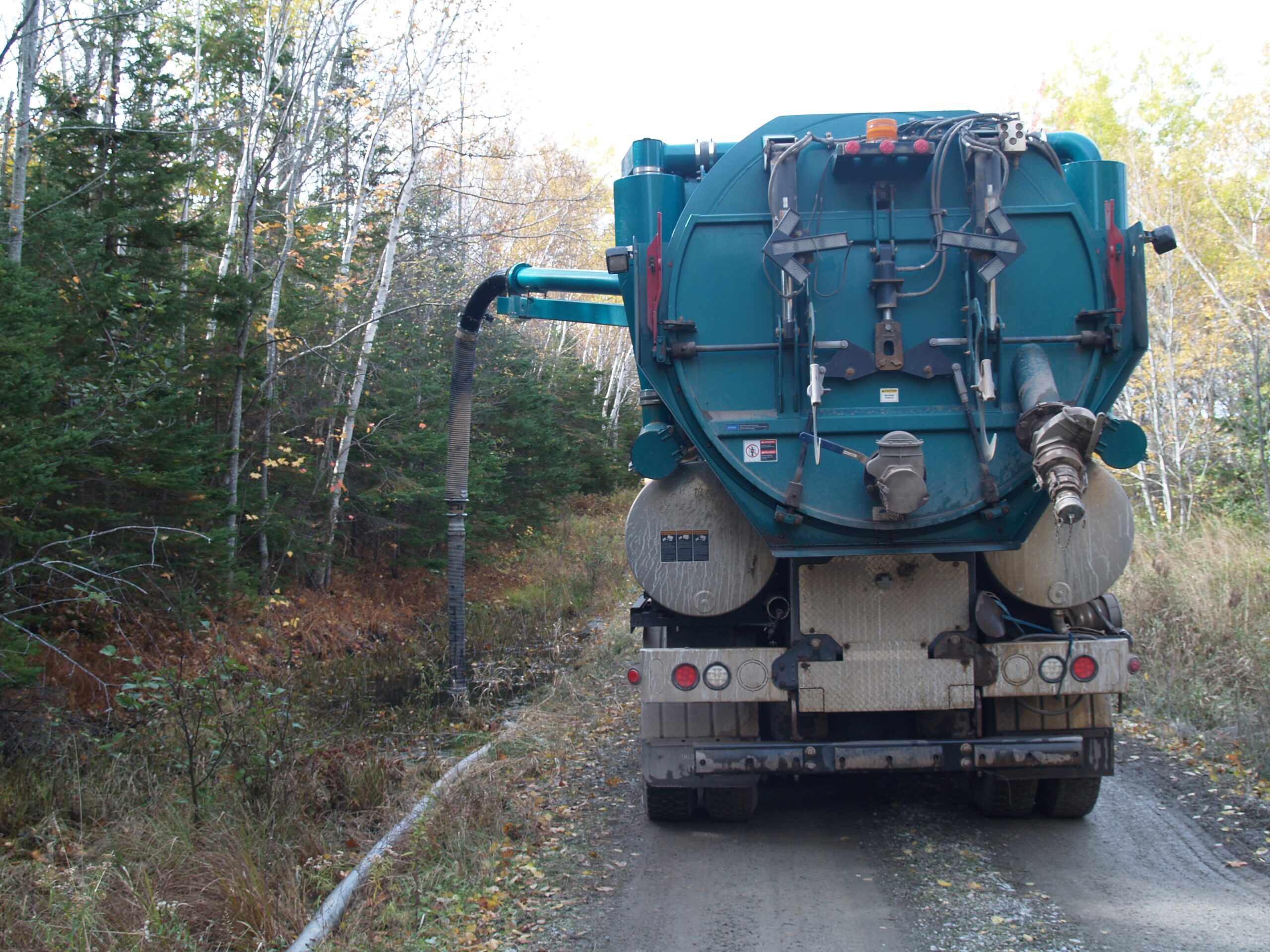 照片显示，2018年，在新斯科省Pictou县印第安十字点，一辆泵车正在吮吸从北部纸浆废水管道破裂泄漏的纸浆废水。