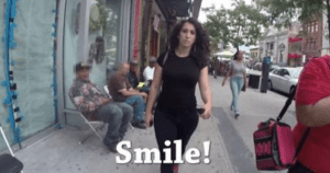 一段视频截图显示，一名女子走在人行道上，周围的男人对她发出嘘声。