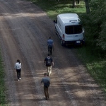 四人在一条土路上拍摄录像的空中镜头