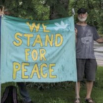 一个人举着标语，读着“我们代表和平”。